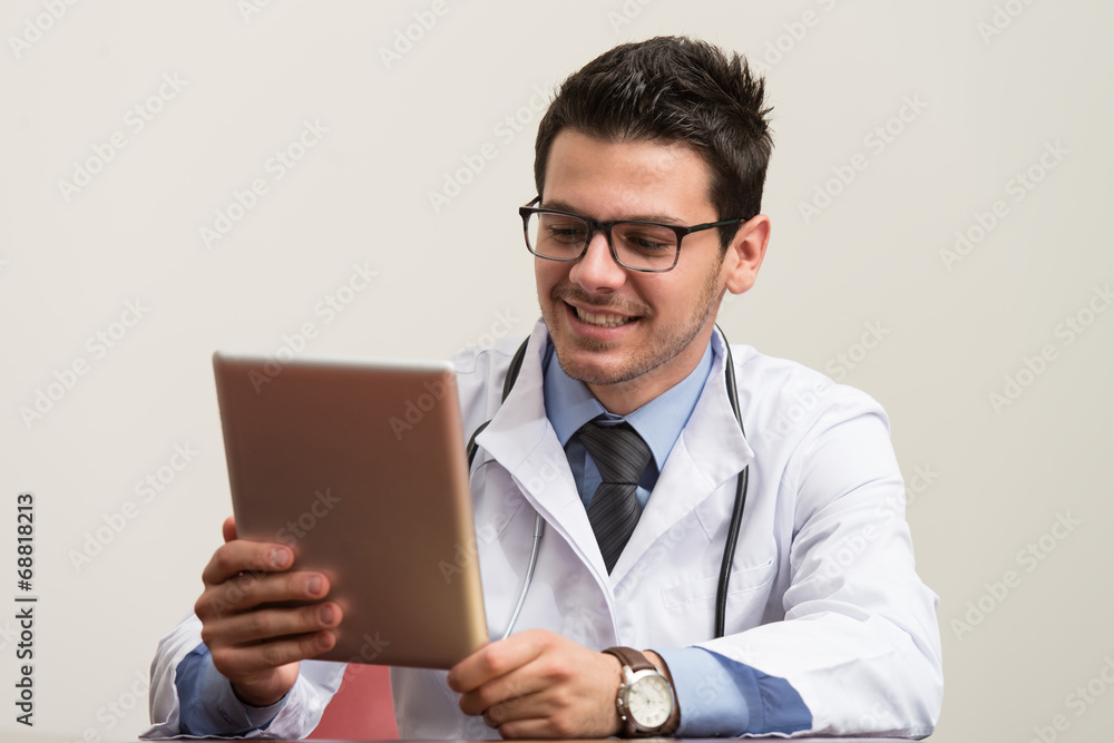 Young Doctor Working On Touchpad In Office Young Doctor Working On Touchpad In Office