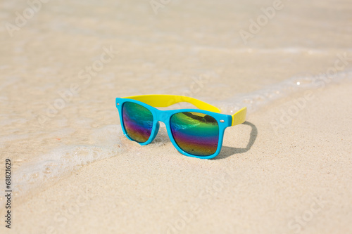Sunglasses lying on sand.
