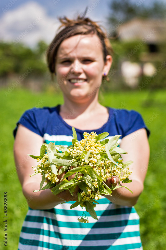 Young woman holding linden leaf and flower Young woman holding linden leaf and flower