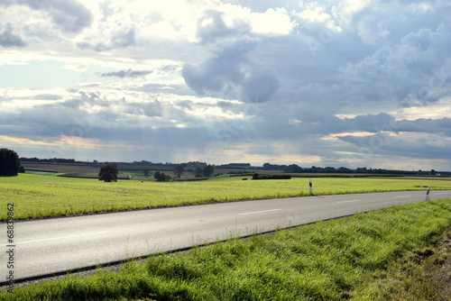 Landstraße vor dramatischer Wolkenkulisse