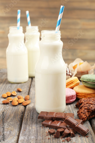 Milk in bottles with paper straws on table