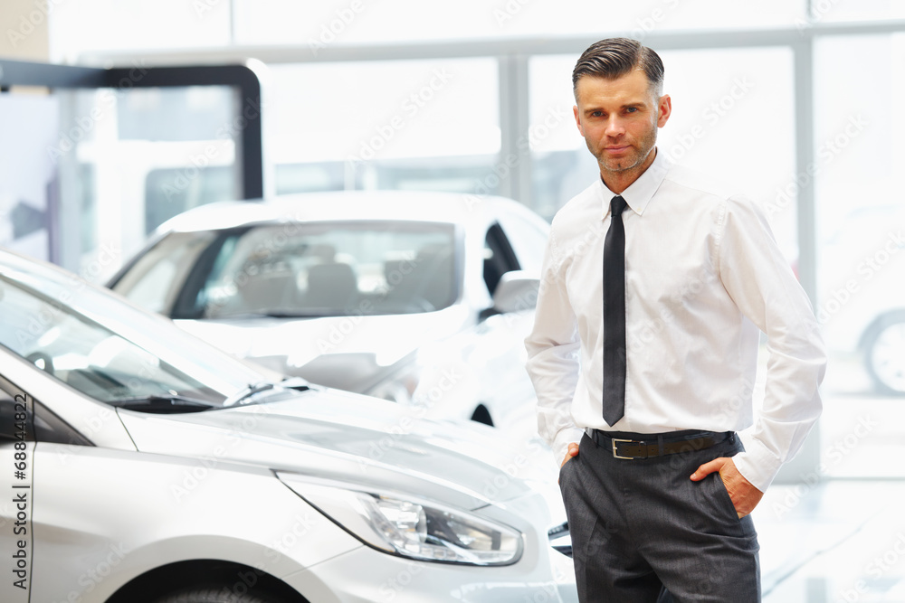 Salesman standing in car retail store. Car Showroom. Salesman standing in car retail store. Car Showroom.