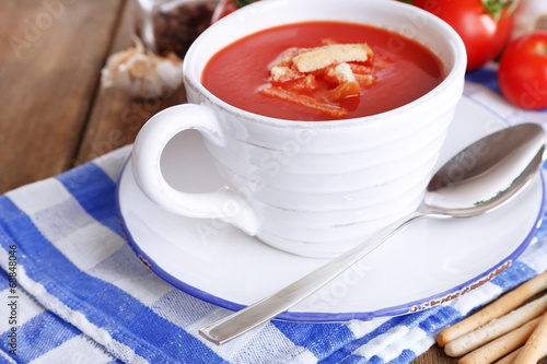 Tasty tomato soup with croutons on wooden table