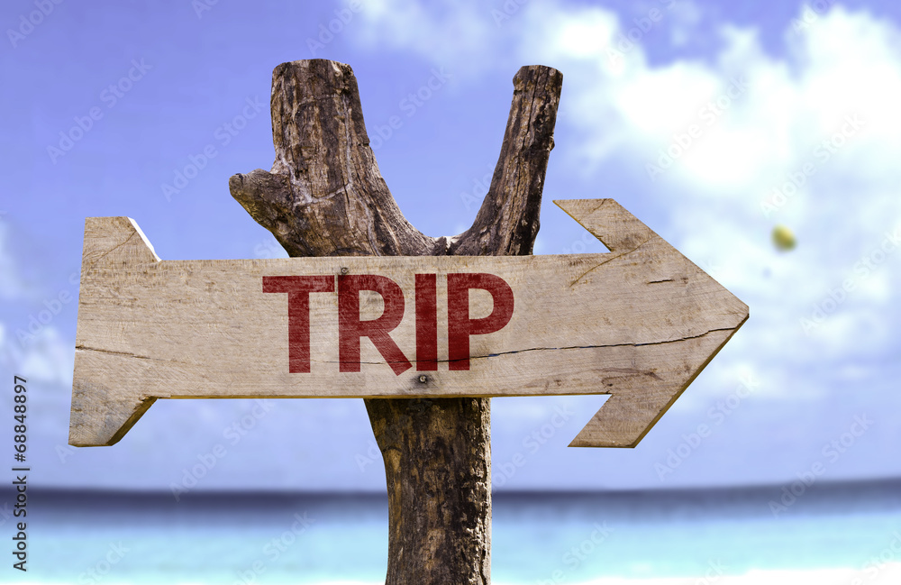 Trip wooden sign with a beach on background