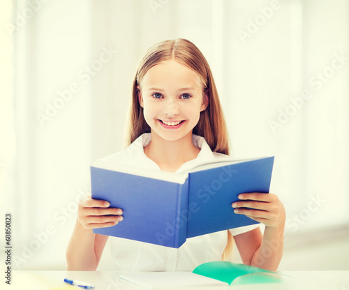 girl studying and reading book at school