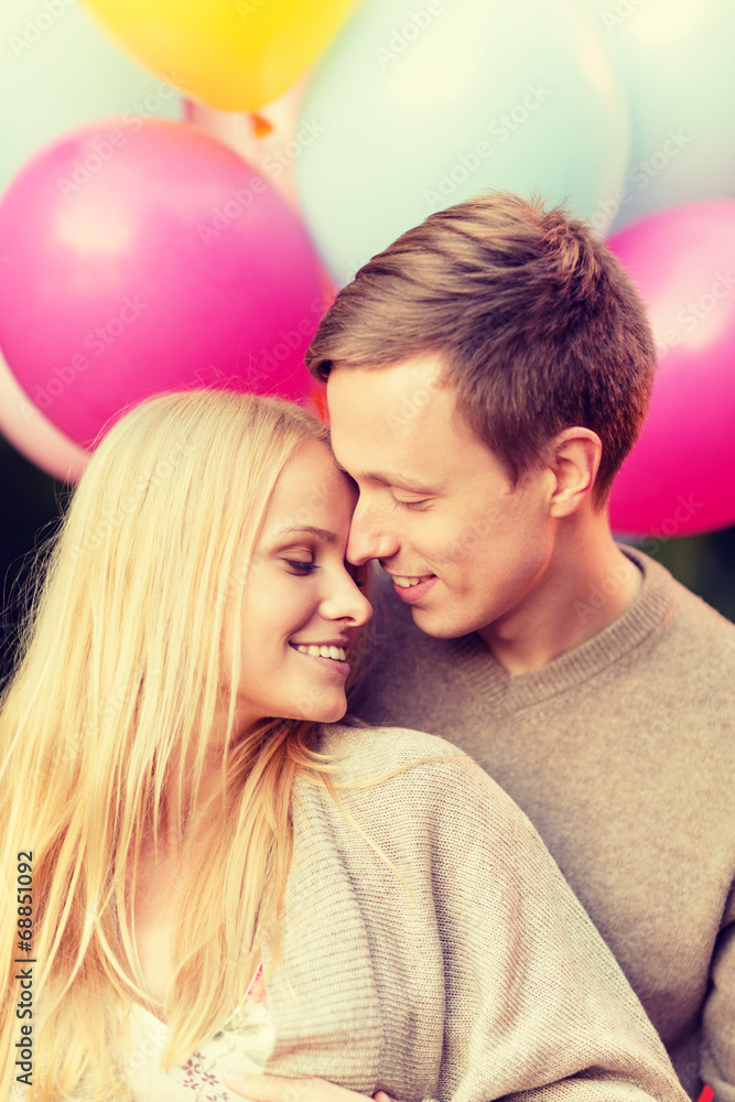 couple with colorful balloons kissing in the park couple with colorful balloons kissing in the park