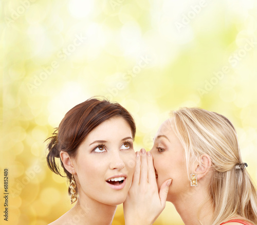 Foto two smiling women whispering gossip