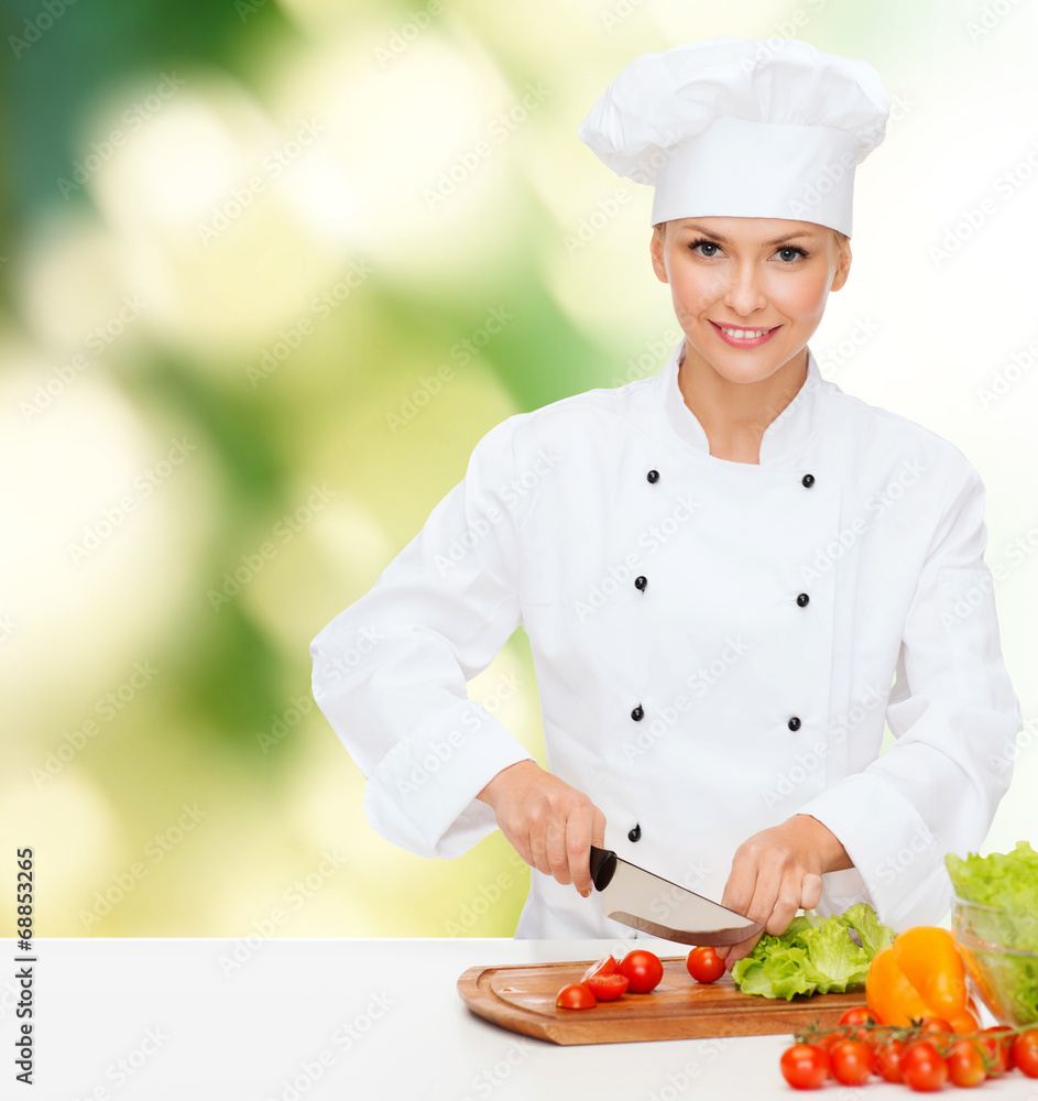 smiling female chef chopping vegetables