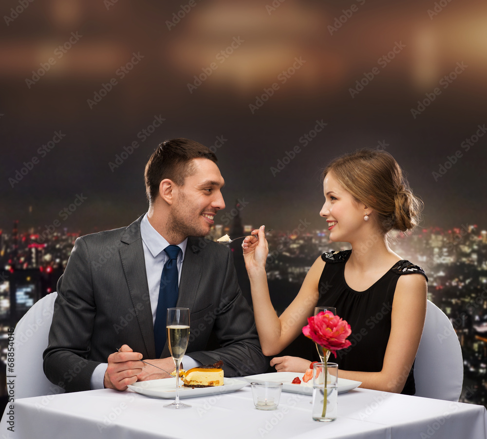 smiling couple eating dessert at restaurant smiling couple eating dessert at restaurant