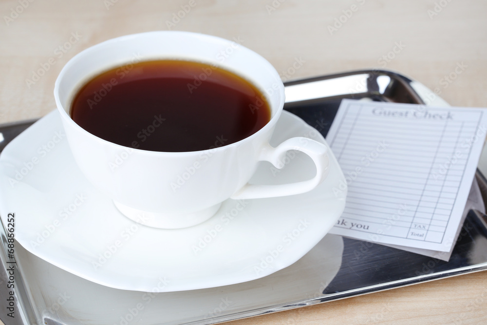 Check and cup of coffee on tray close-up Check and cup of coffee on tray close-up