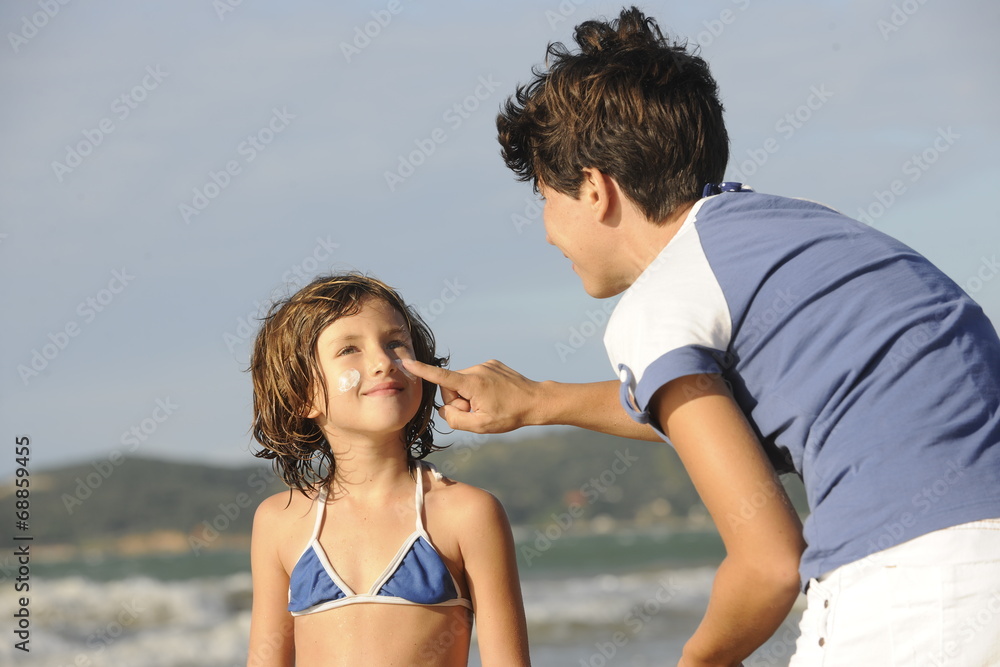 Mother applying sunscreen to daughter at beach. Mother applying sunscreen to daughter at beach.