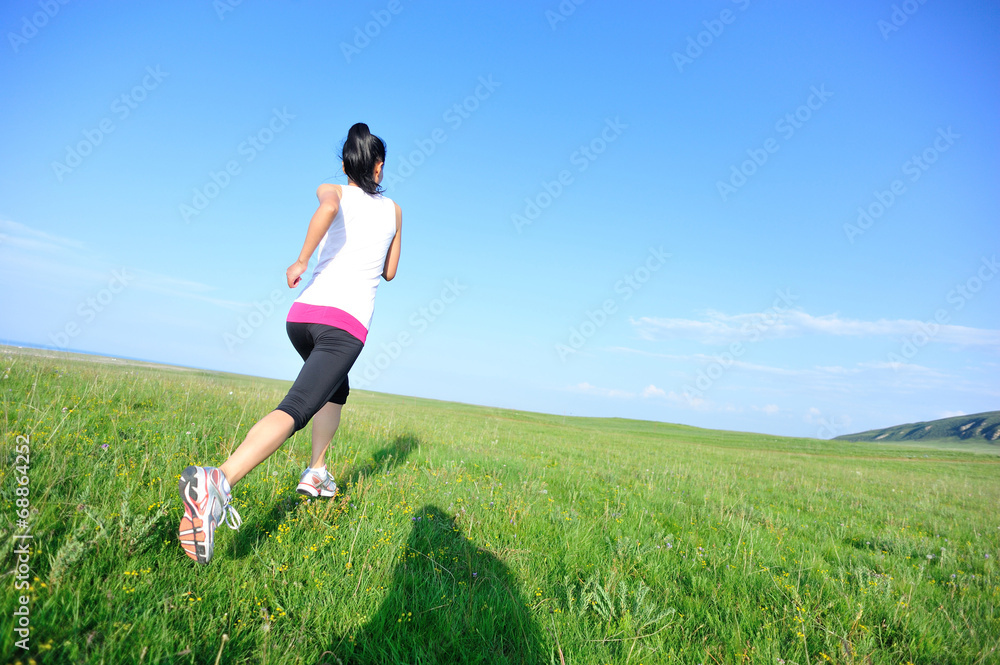 Runner athlete legs running on grass seaside Runner athlete legs running on grass seaside