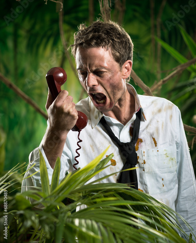 Furious businessman on the phone lost in jungle