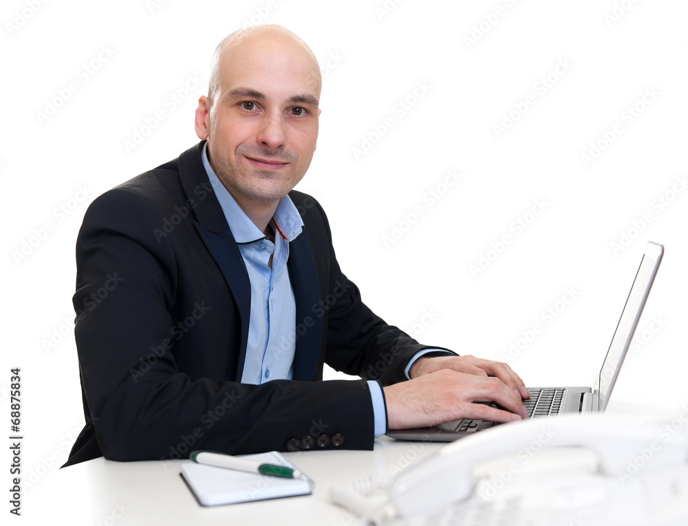 businessman sitting at desk, working on laptop computer businessman sitting at desk, working on laptop computer