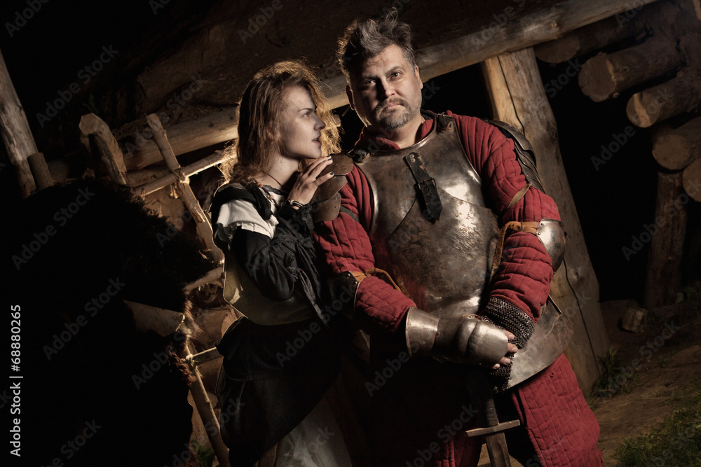 Medieval peasant woman is embracing her knight.