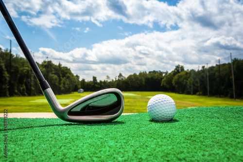 Close-up of a golf ball and a golf iron on a driving range