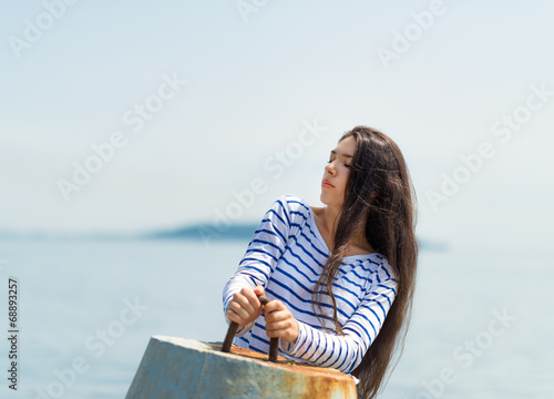 Girl in a striped T-shirt keeps for the breakwater. © Vladimir Arndt