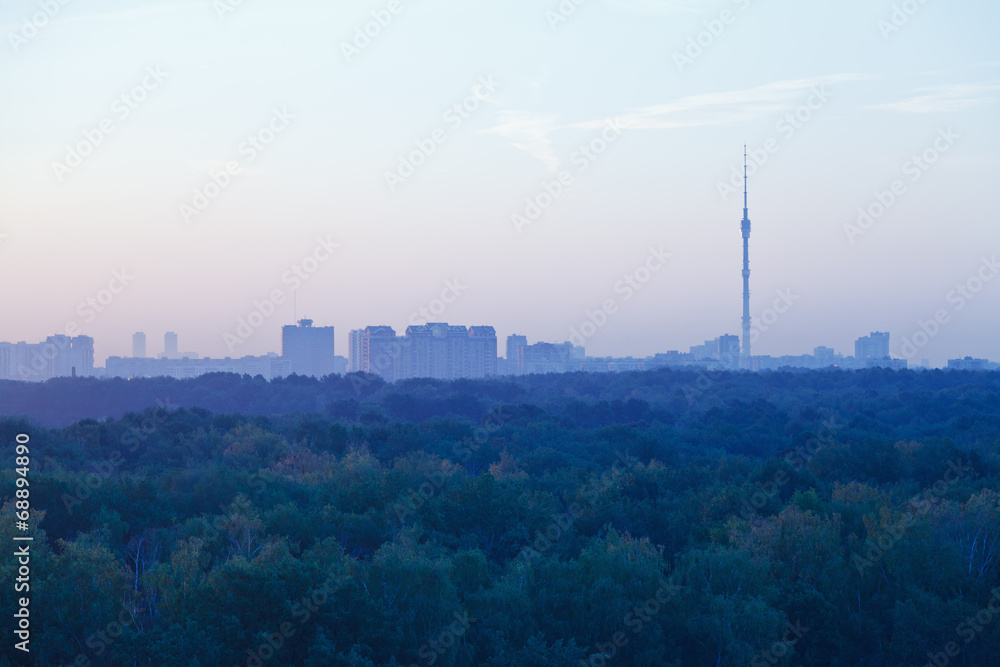 TV tower and urban houses in early blue dawn