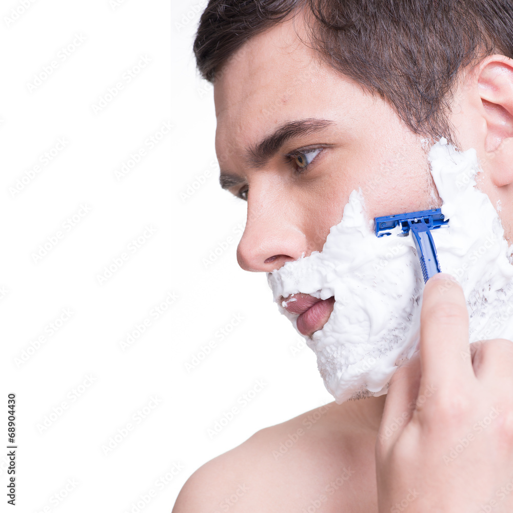 young man shaving the  beard with the razor