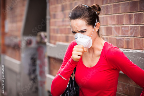 Woman wearing facemask coughing photo