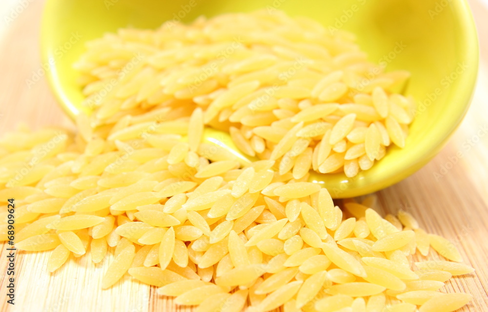 Yellow pasta pouring out of glass bowl Yellow pasta pouring out of glass bowl