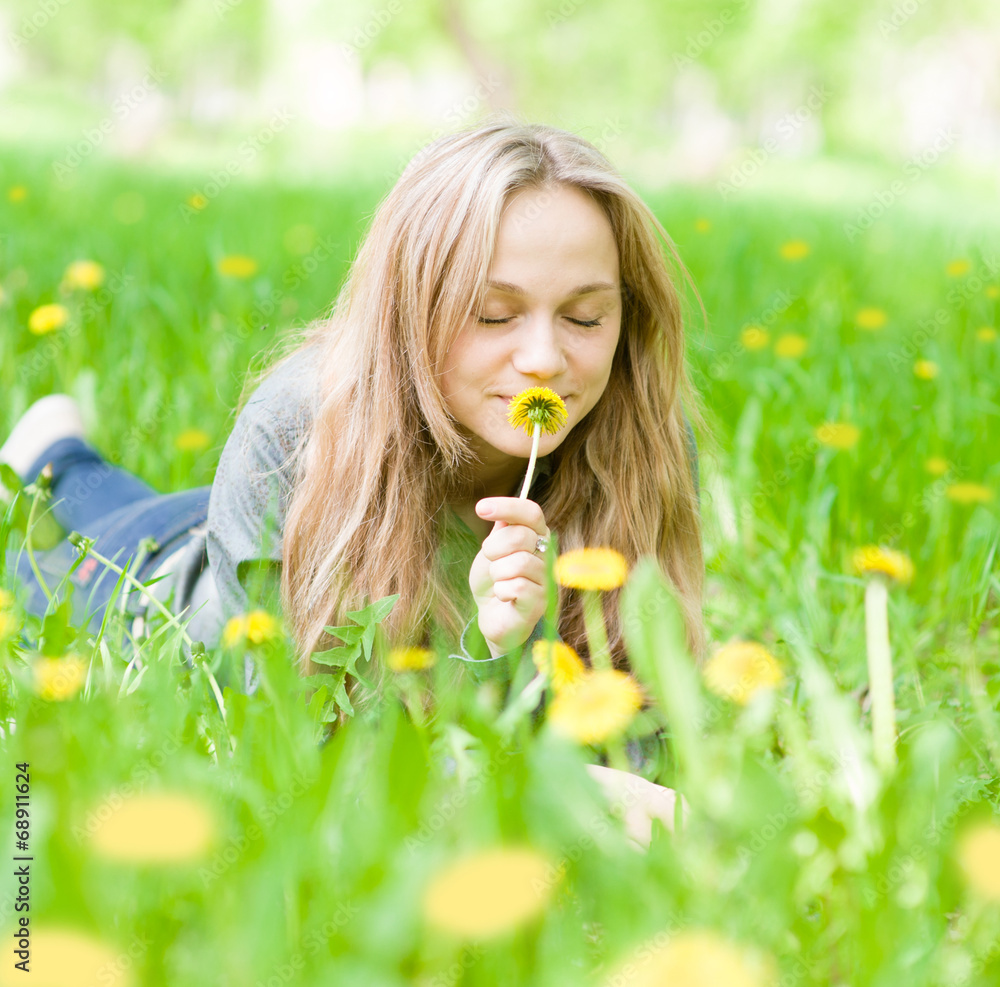 beautiful girl lying on the grass and smelling dandelion beautiful girl lying on the grass and smelling dandelion