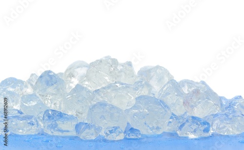 Chunks of crushed ice on blue surface and white background