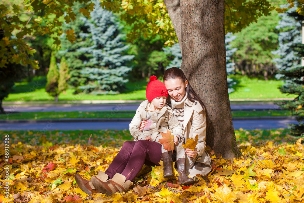 Little girl and young mom in yellow autumn park on sunny day Little girl and young mom in yellow autumn park on sunny day