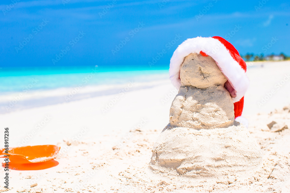 Sandy snowman with red Santa Hat on white Caribbean beach Sandy snowman with red Santa Hat on white Caribbean beach