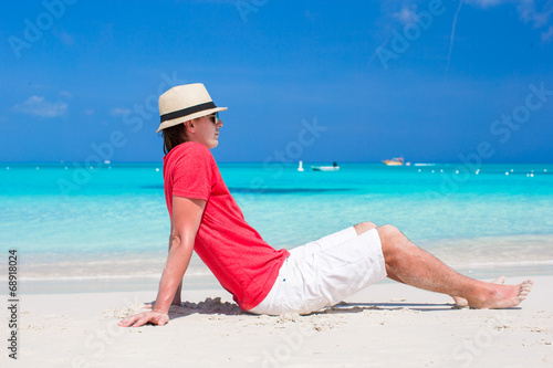 Young happy man enjoying summer vacation on tropical beach