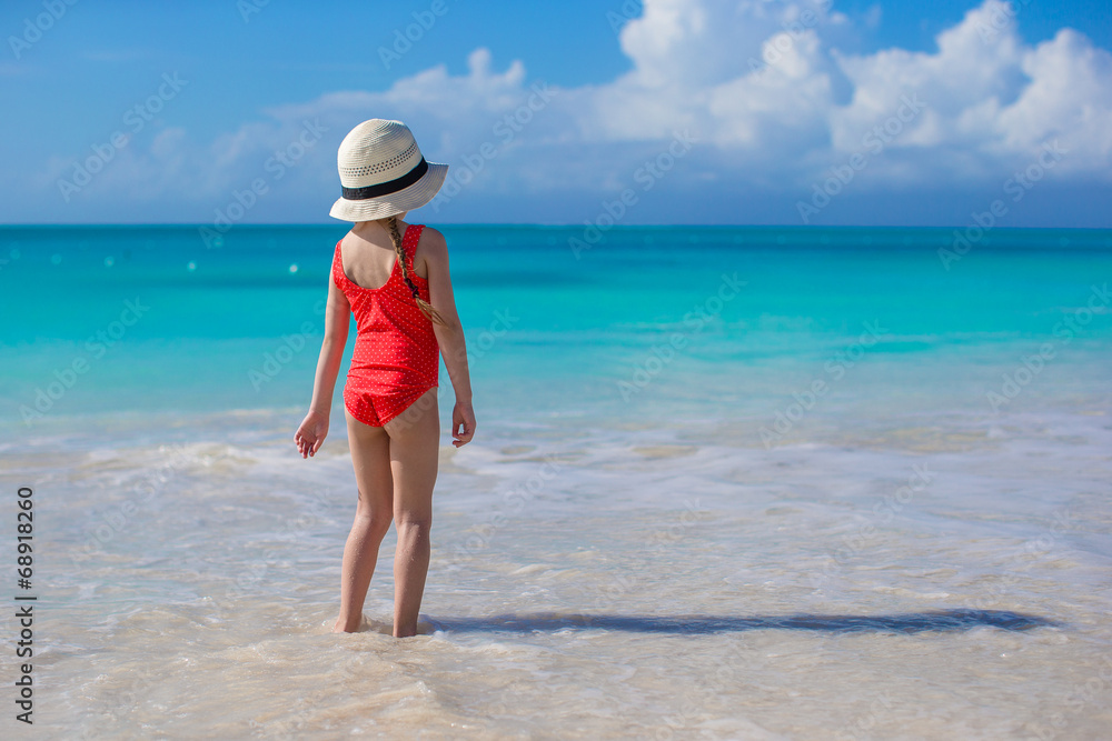 Little girl in hat at beach during caribbean vacation
