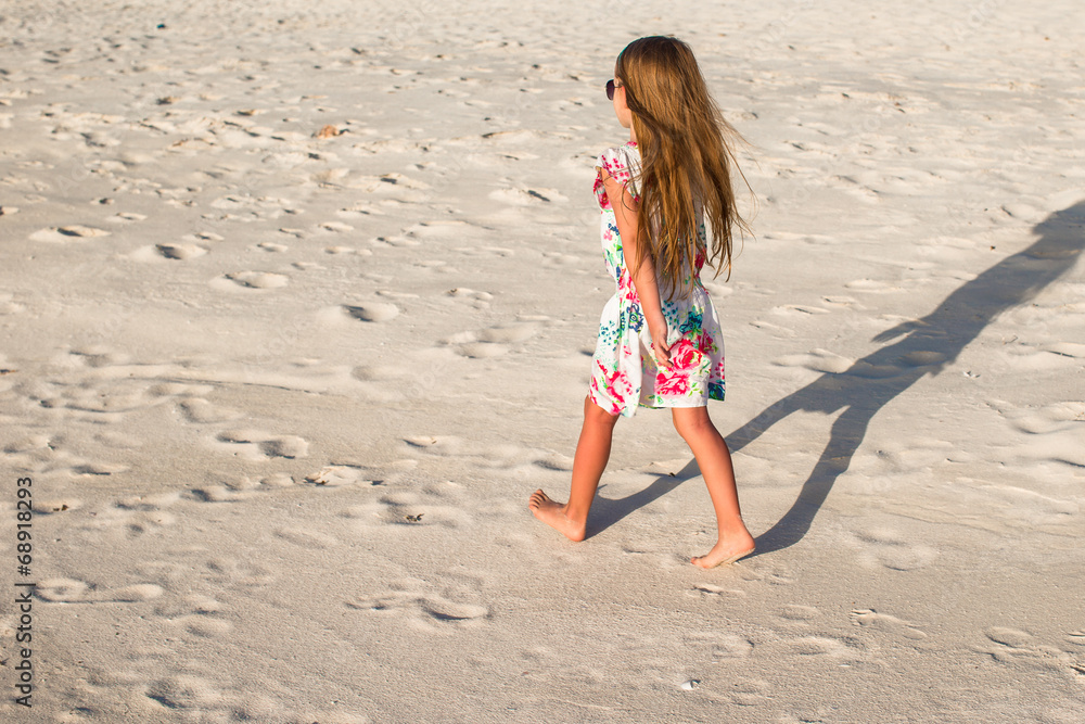 Happy little girl on beach during summer vacation