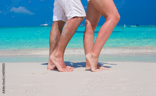 Close up male and female feet on white sand