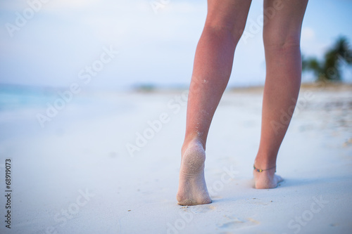 Close up of male legs on white sandy beach