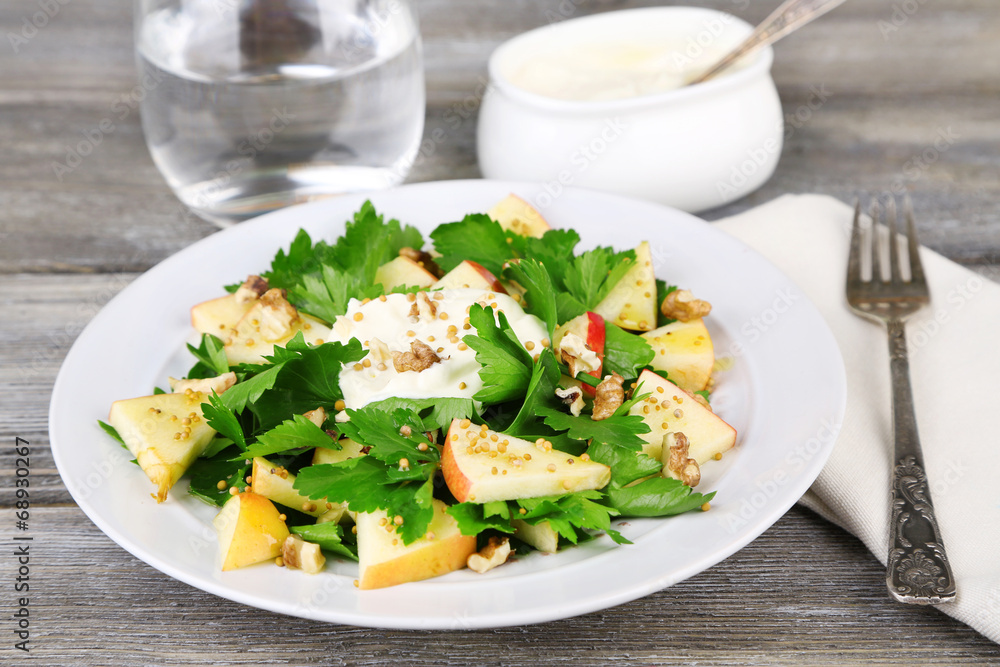 Green salad with apples, walnuts and cheese on wooden Green salad with apples, walnuts and cheese on wooden