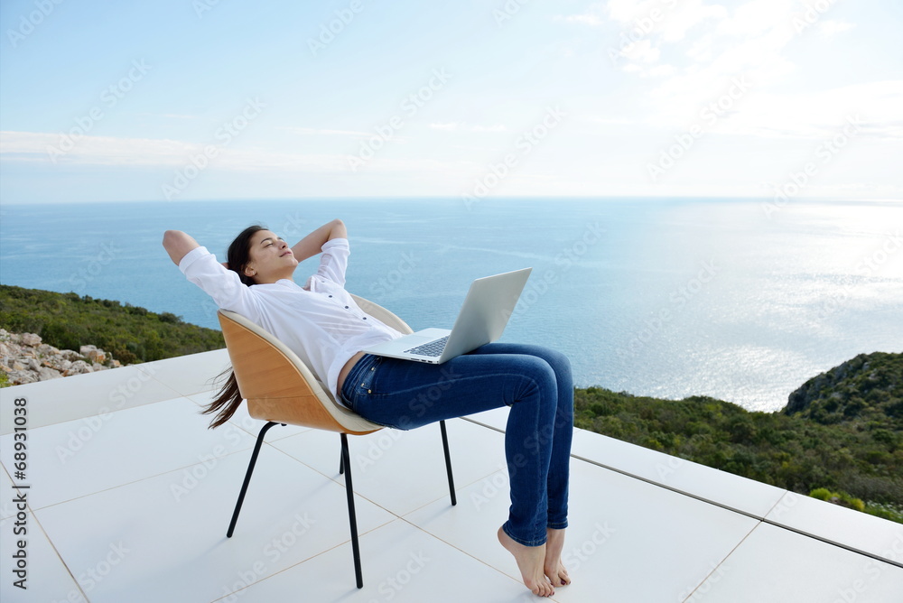 relaxed young woman at home working on laptop