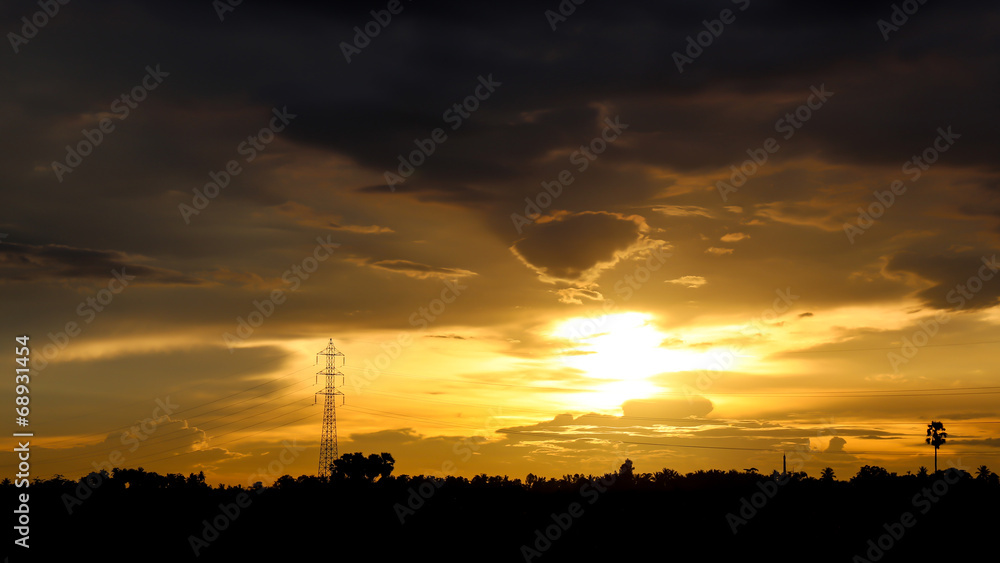 Sunset over the forests and poles for high voltage.