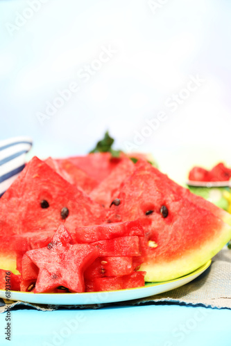 Fresh slices of watermelon on table, on bright background