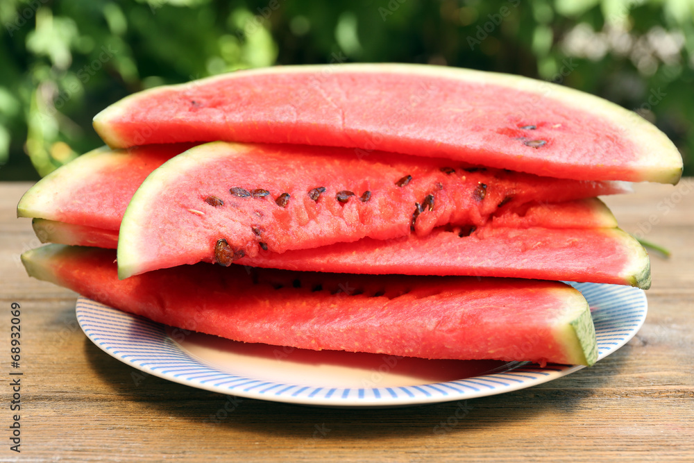 Fresh slice of watermelon on table outdoors, close up Fresh slice of watermelon on table outdoors, close up