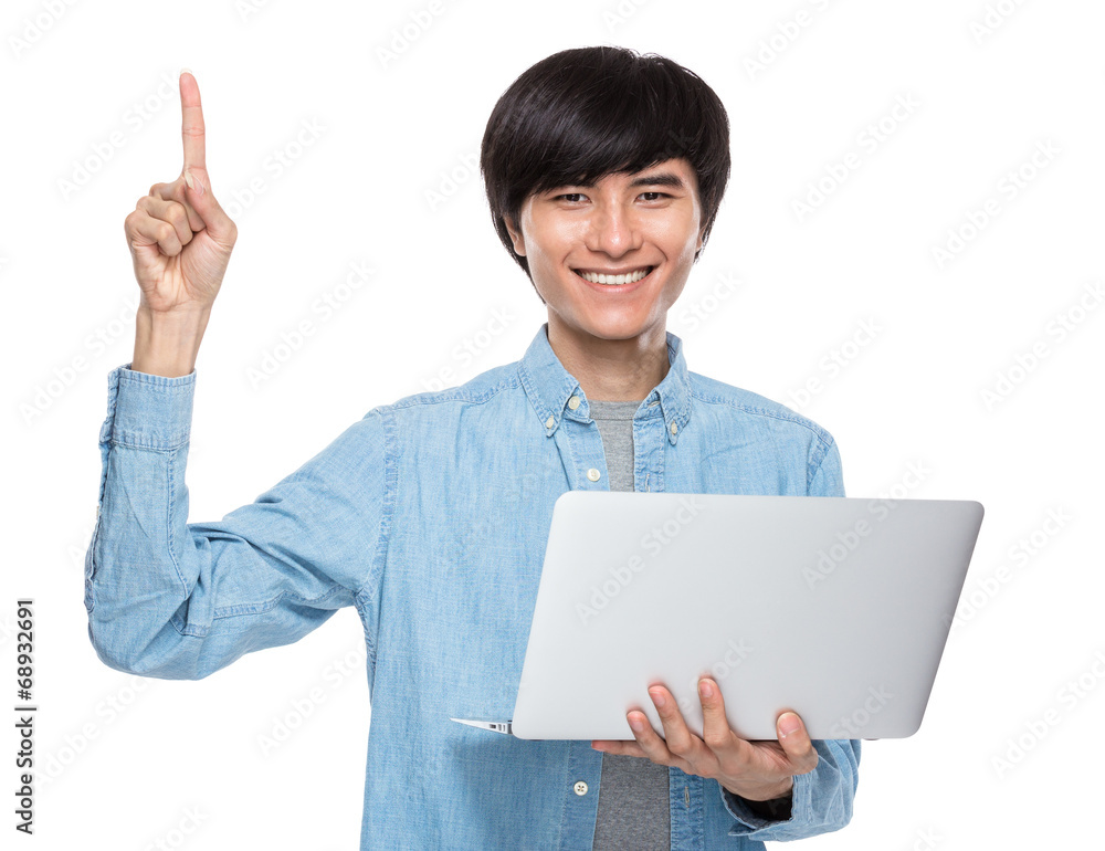 Asian young man with laptop computer and finger point up Asian young man with laptop computer and finger point up