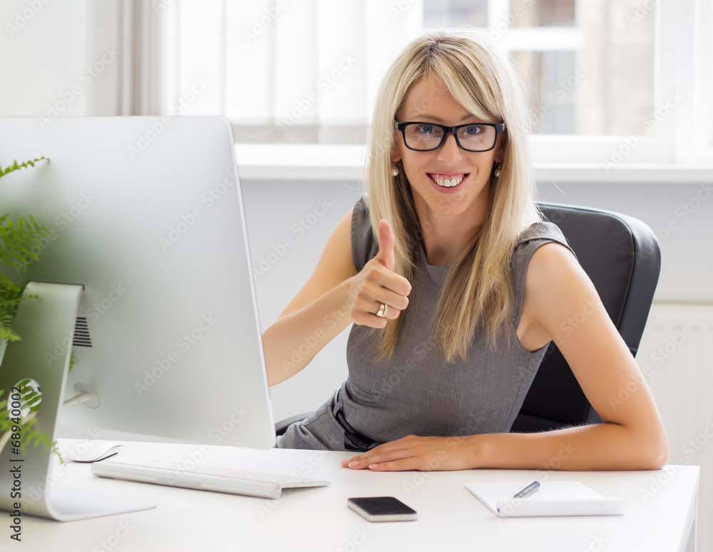 Young smiling businesswoman showing thumbs up gesture Young smiling businesswoman showing thumbs up gesture