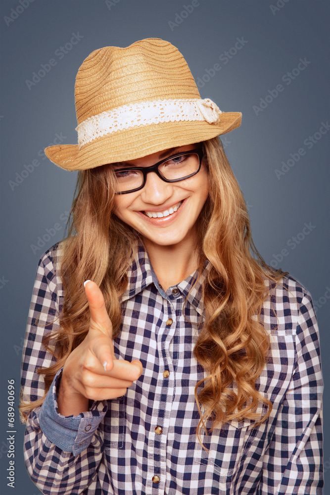 portrait of a smiling young woman with casual garb pointing a f portrait of a smiling young woman with casual garb pointing a f