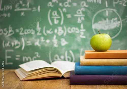 Obraz Podręczniki szkolne z jabłkiem na biurku
