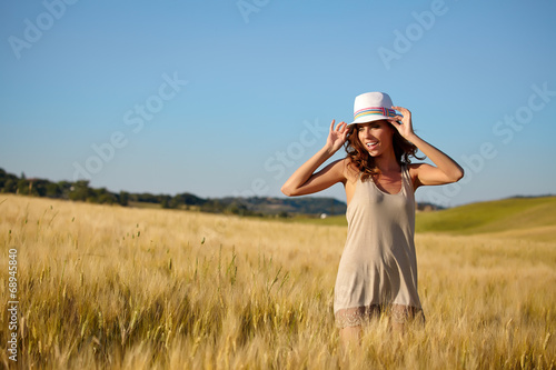 Portrait of a woman on golden cereal field in summer