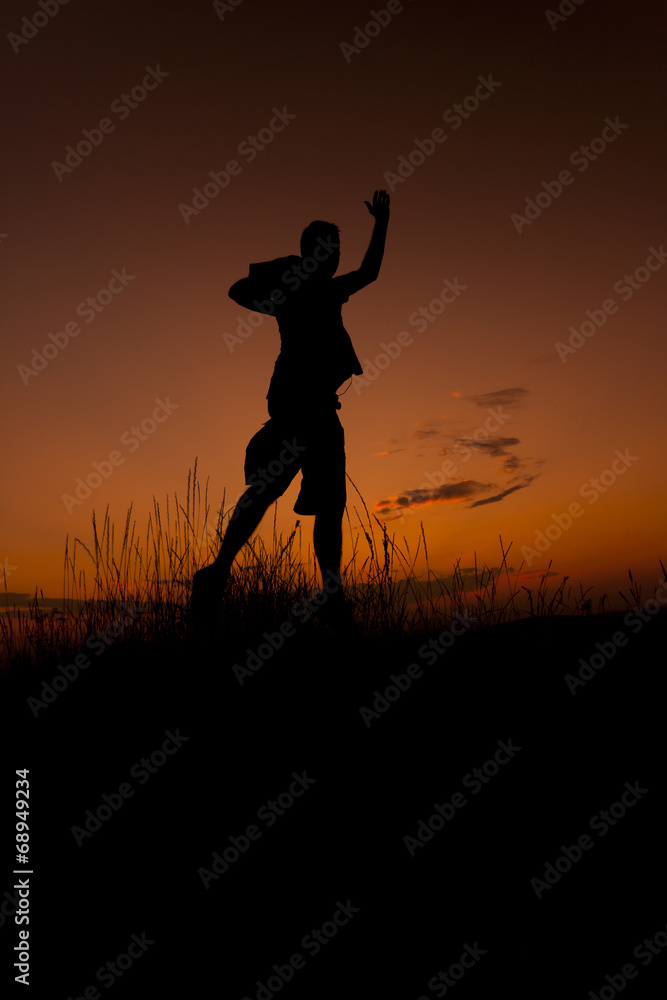 Happy man jumping. Silhouette in the sunset sky