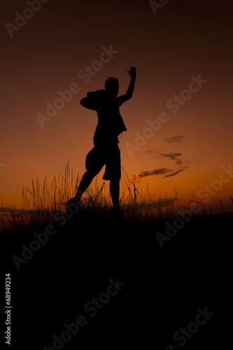 Happy man jumping. Silhouette in the sunset sky