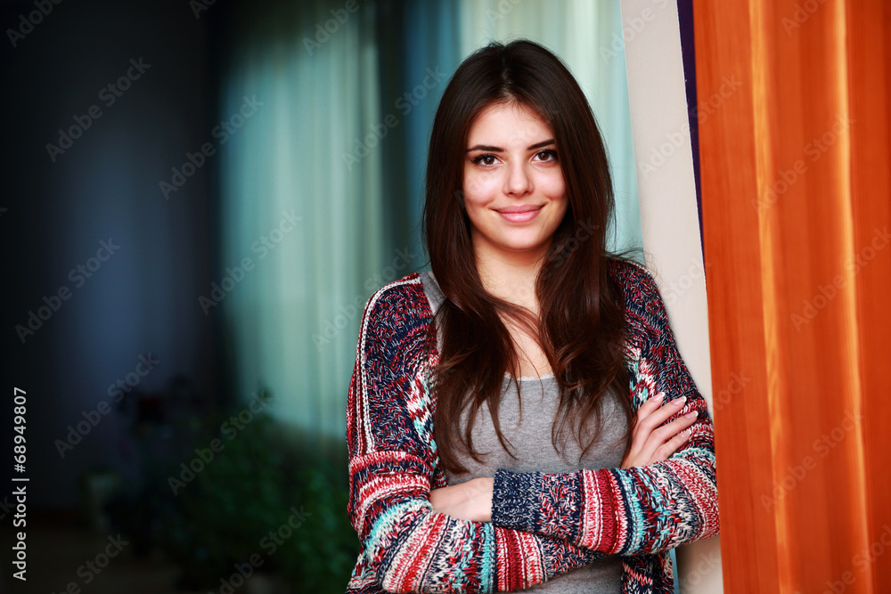 Portrait of a cute happy woman standing with arms folded at home Portrait of a cute happy woman standing with arms folded at home