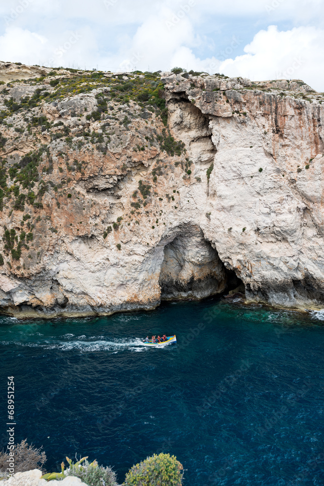 Caves and cliffs at the coast of Gozo Island tourists