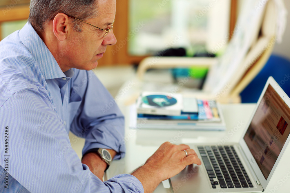Portrait of senior caucasian man working on his laptop computer. Portrait of senior caucasian man working on his laptop computer.