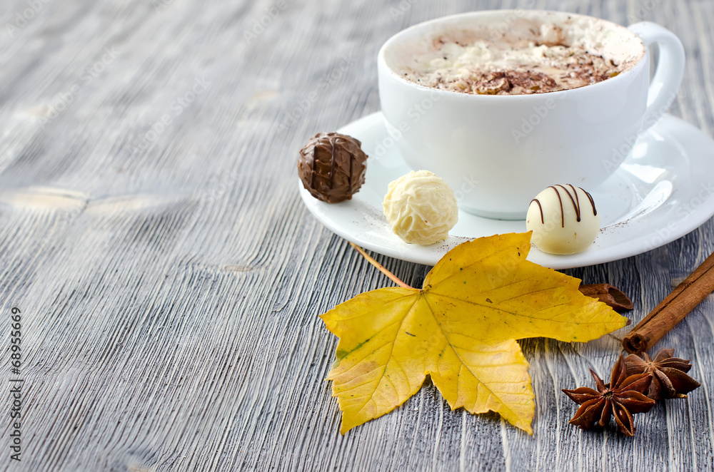 Cup of cappuccino, pralines and autumn leaves copy space Cup of cappuccino, pralines and autumn leaves copy space